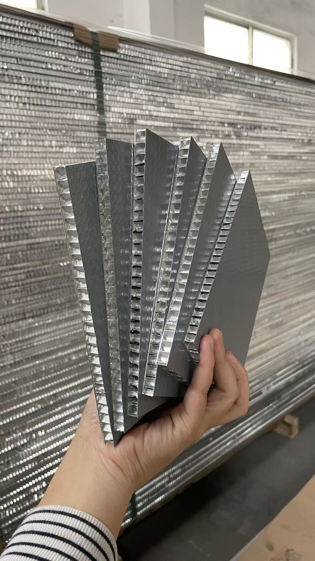 Hand-held aluminum honeycomb panel samples showing the aluminum skins and honeycomb core